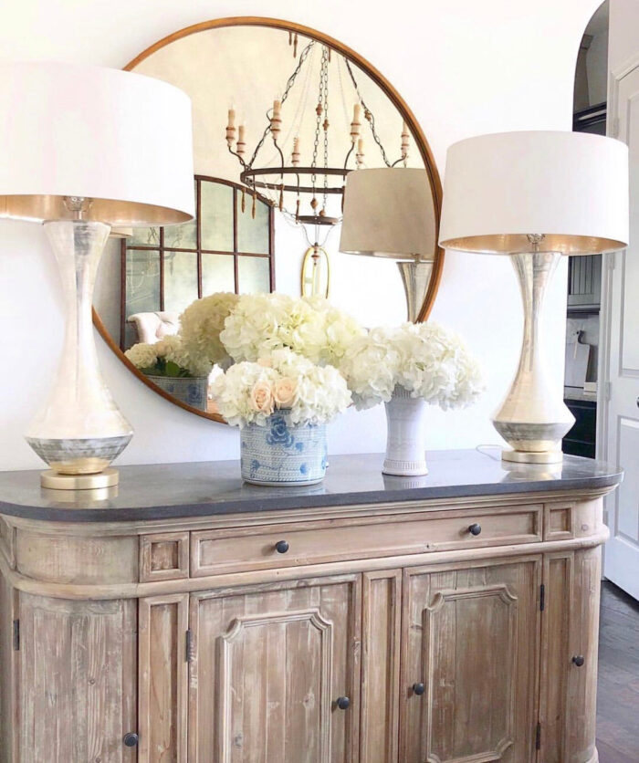 Image of gold round mirror with lamps and cabinet